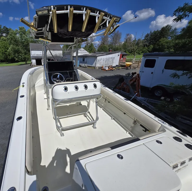 Slide: The Image of 2002 Hydra-Sports 2390 CC Vector boat with T-top and rod holders, parked outdoors. - 33