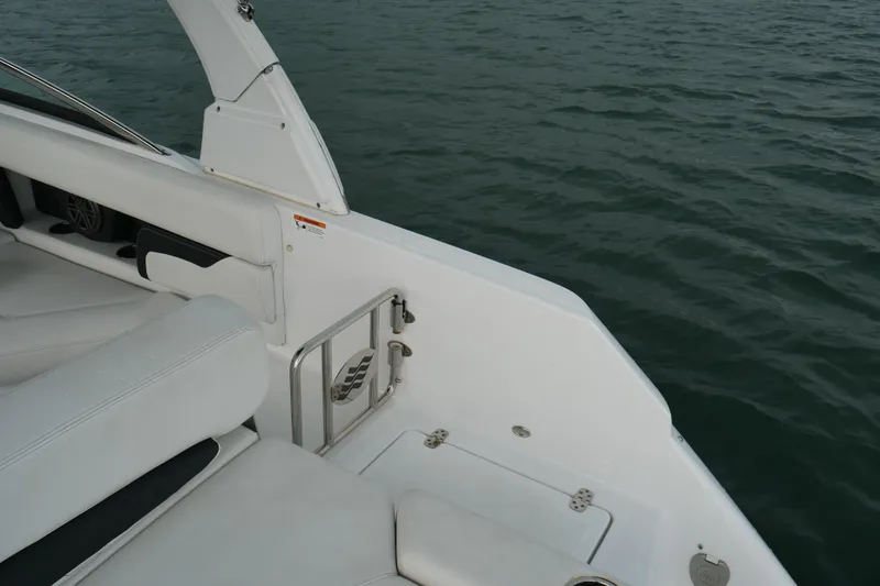 Slide: The Image of 2022 Four Winns HD5 OB boat interior with white seating, overlooking calm water. - 15