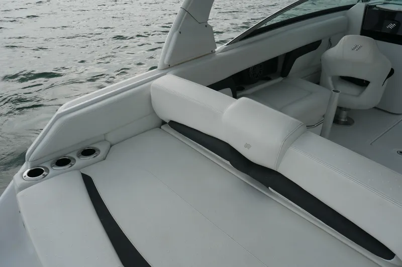 Slide: The Image of 2022 Four Winns HD5 OB boat interior with white seating and cup holders. - 16