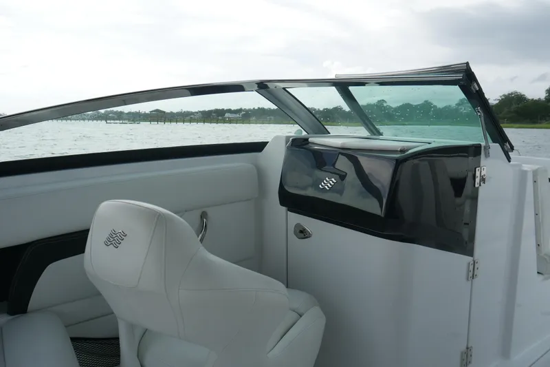 Slide: The Image of 2022 Four Winns HD5 OB boat interior with white seating and sleek dashboard design. - 17