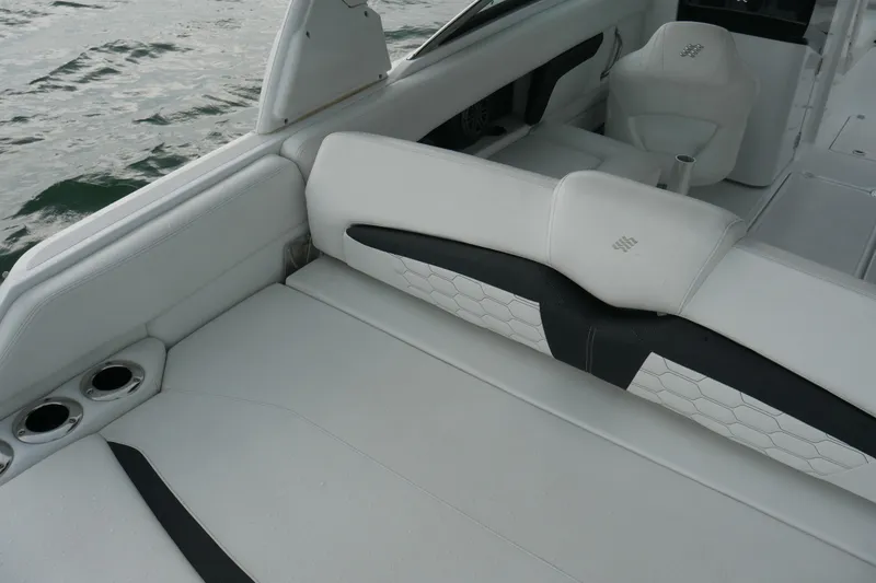 Slide: The Image of 2022 Four Winns HD5 OB boat interior with white seating and cup holders. - 20