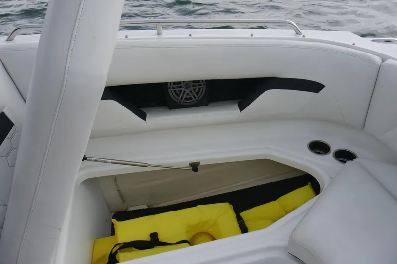 Slide: The Image of 2022 Four Winns HD5 OB boat interior with storage compartment and cup holders. - 21