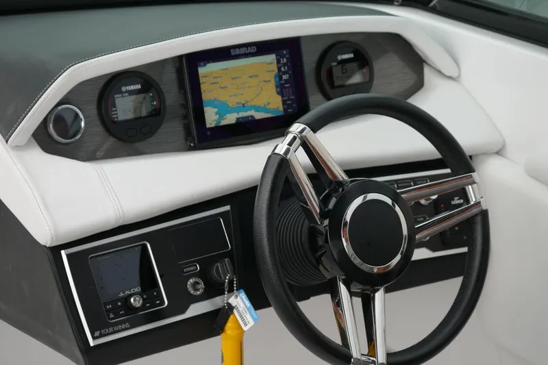 Slide: The Image of 2022 Four Winns HD5 OB boat dashboard with steering wheel and navigation display. - 26