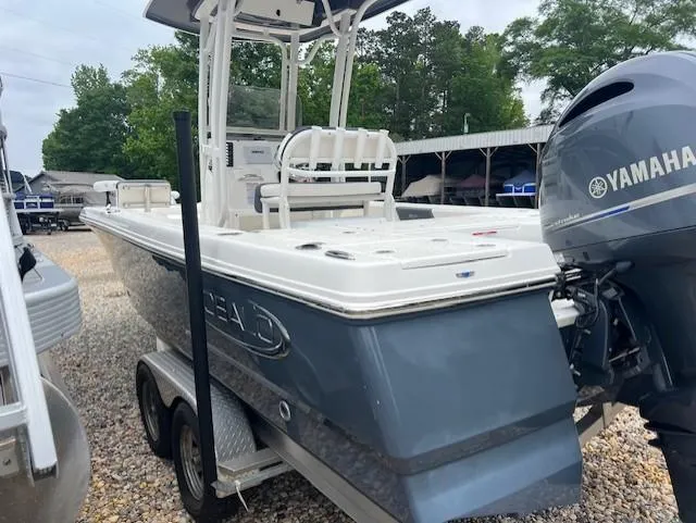 Slide: The Image of 2021 Robalo 226 Cayman boat with Yamaha engine on a trailer, parked outdoors. - 2