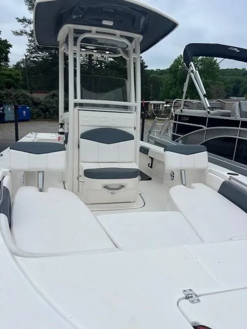 Slide: The Image of 2021 Robalo 226 Cayman boat with seating and console, docked near other boats. - 4