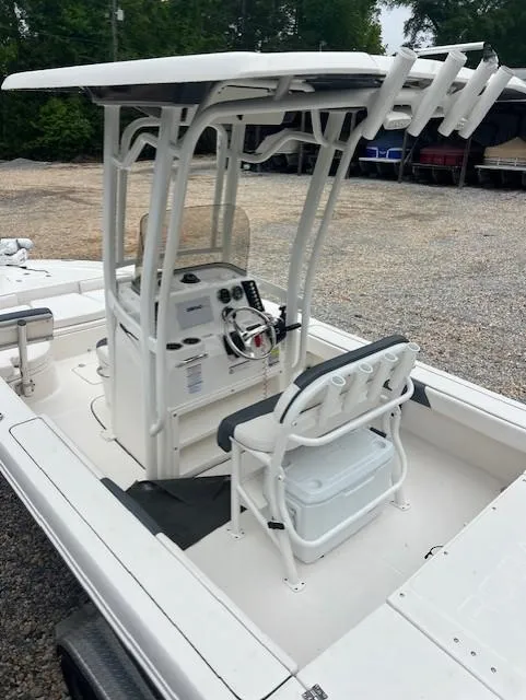 Slide: The Image of 2021 Robalo 226 Cayman boat with T-top and center console in a gravel lot. - 6