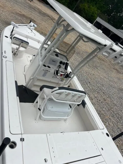 Slide: The Image of 2021 Robalo 226 Cayman boat with center console and T-top, parked on gravel. - 7