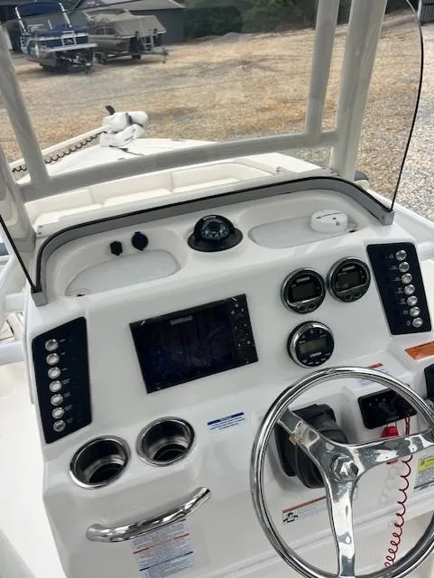 Slide: The Image of 2021 Robalo 226 Cayman boat dashboard with steering wheel and navigation controls. - 8