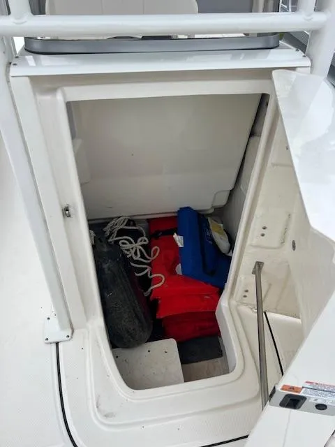Slide: The Image of Storage compartment on a 2021 Robalo 226 Cayman boat with life jackets and ropes. - 9