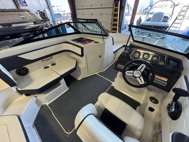 Slide: The Image of Interior of a 2015 Sea Ray 190 Sport boat, featuring steering wheel and seating. - 10