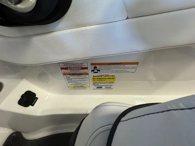 Slide: The Image of 2015 Sea Ray 190 Sport interior with safety warning labels and seating details. - 12