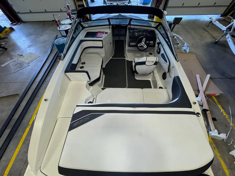 Slide: The Image of 2015 Sea Ray 190 Sport boat interior, featuring seating and steering wheel in a garage setting. - 4