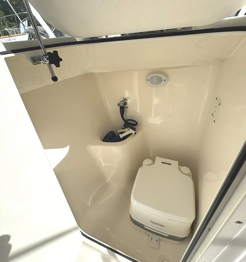 Slide: The Image of 2022 Key West 203 DFS boat interior with portable toilet and storage space. - 17