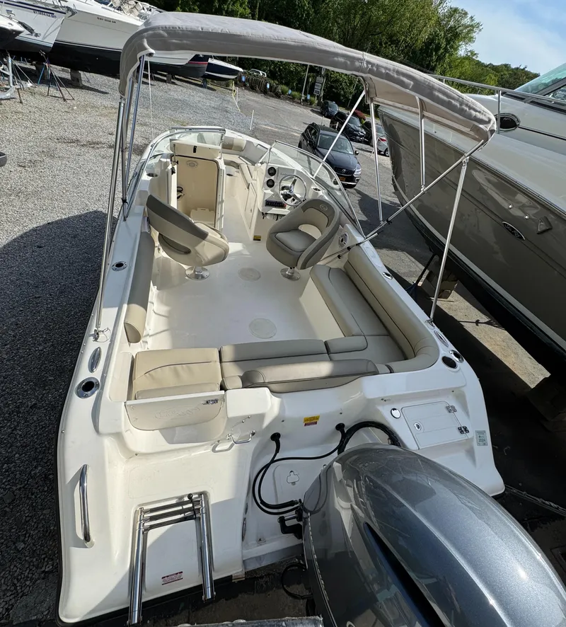 Slide: The Image of 2022 Key West 203 DFS boat with seating and canopy, parked outdoors. - 5