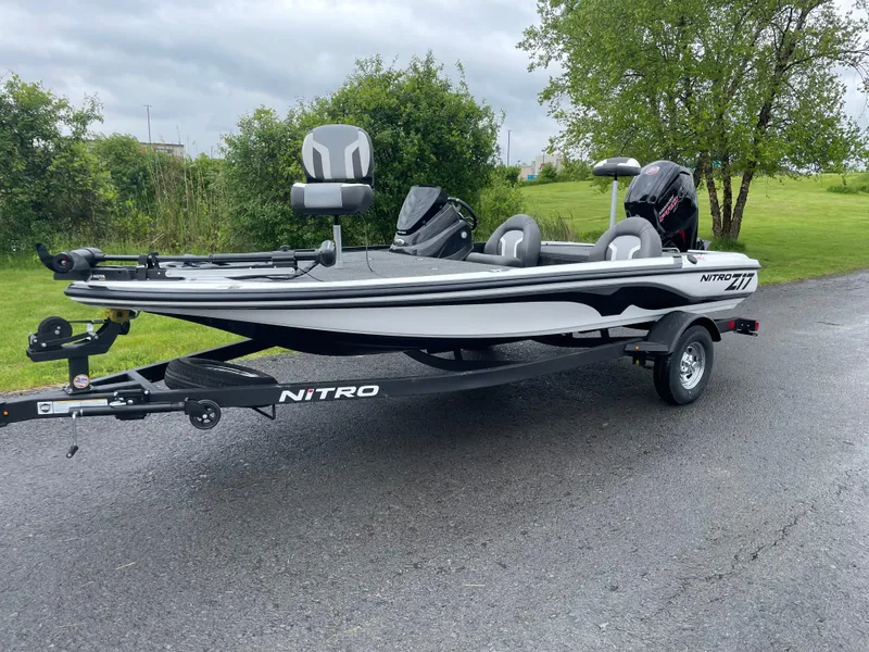 Slide: The Image of 2025 Nitro Z17 fishing boat on trailer, parked on paved road, surrounded by greenery. - 0