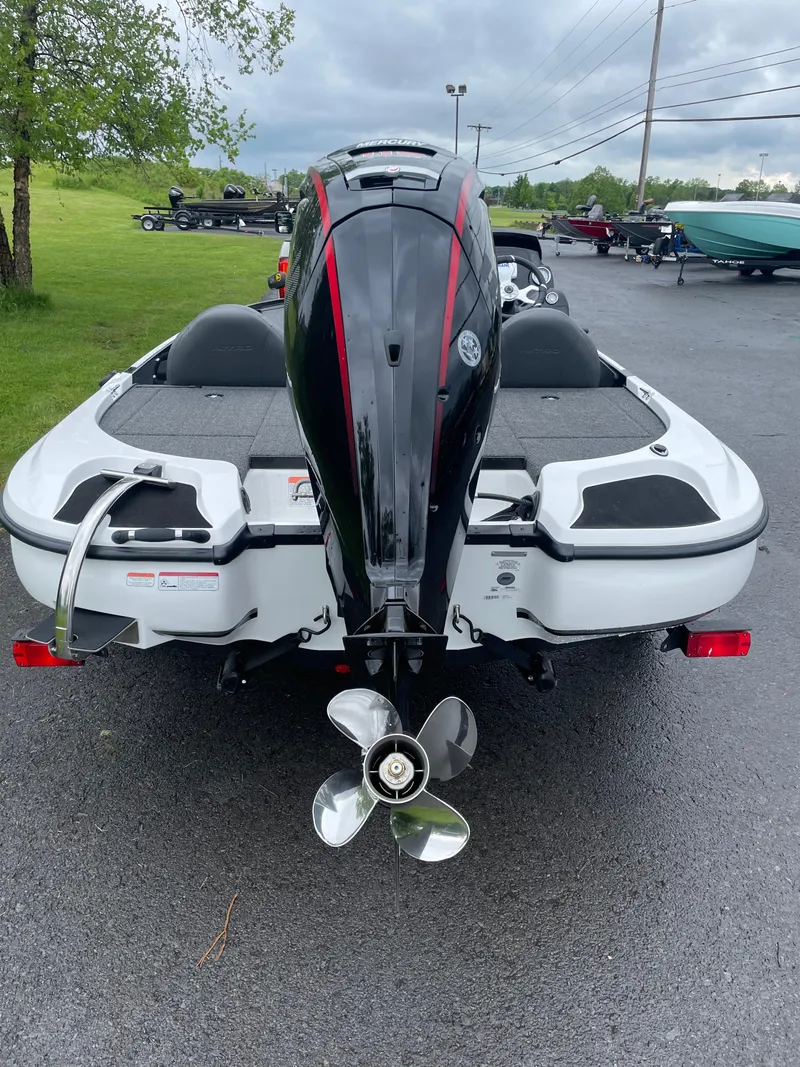 Slide: The Image of 2025 Nitro Z17 boat, rear view with powerful outboard motor, parked on asphalt. - 3