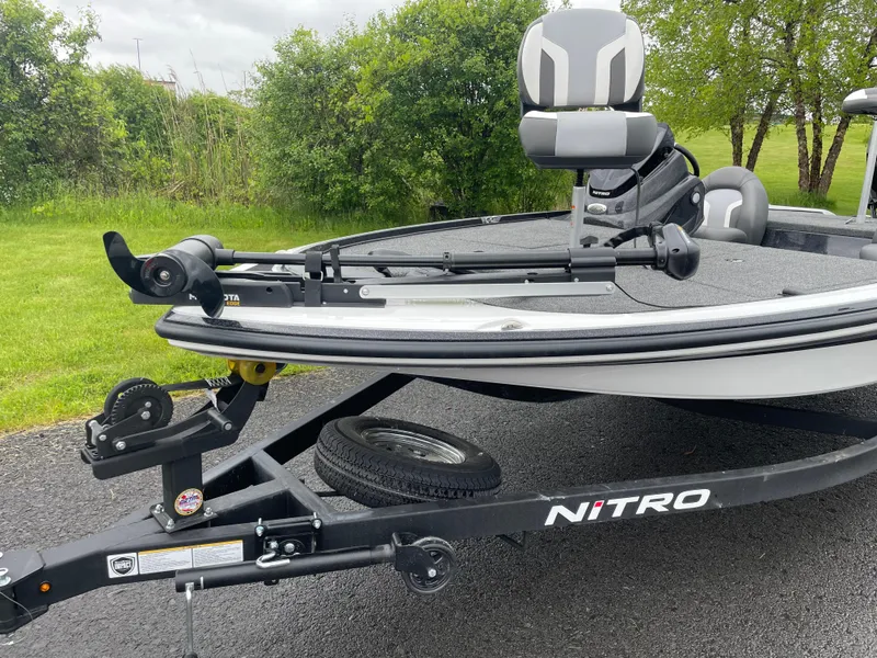 Slide: The Image of 2025 Nitro Z17 boat on trailer, parked on asphalt near greenery. - 5