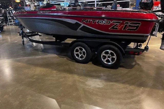 The Image of 2025 Nitro ZV19 Sport boat on display in showroom, red and black design. - 0
