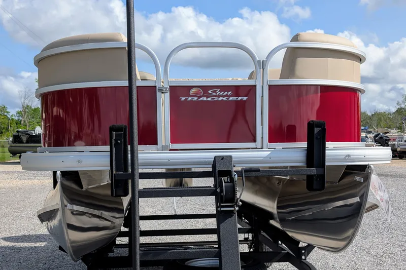 Slide: The Image of 2025 Sun Tracker Party Barge 18 DLX pontoon boat, red exterior, parked on trailer. - 3