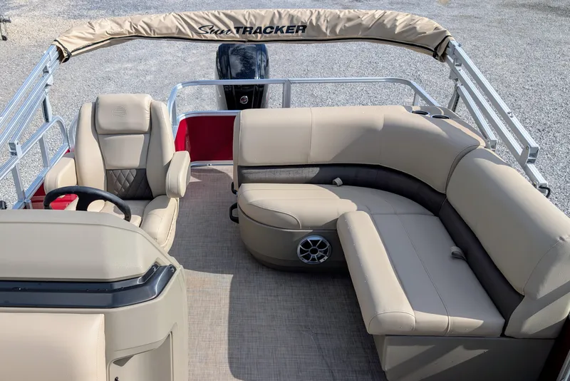 Slide: The Image of 2025 Sun Tracker Party Barge 18 DLX interior with beige seating and steering console. - 7