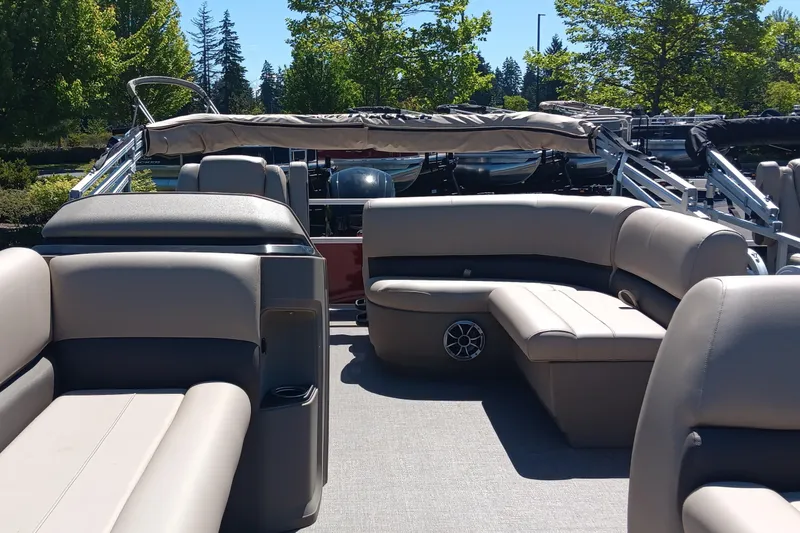 Slide: The Image of 2025 Sun Tracker Party Barge 18 DLX interior with beige seating and open deck. - 2
