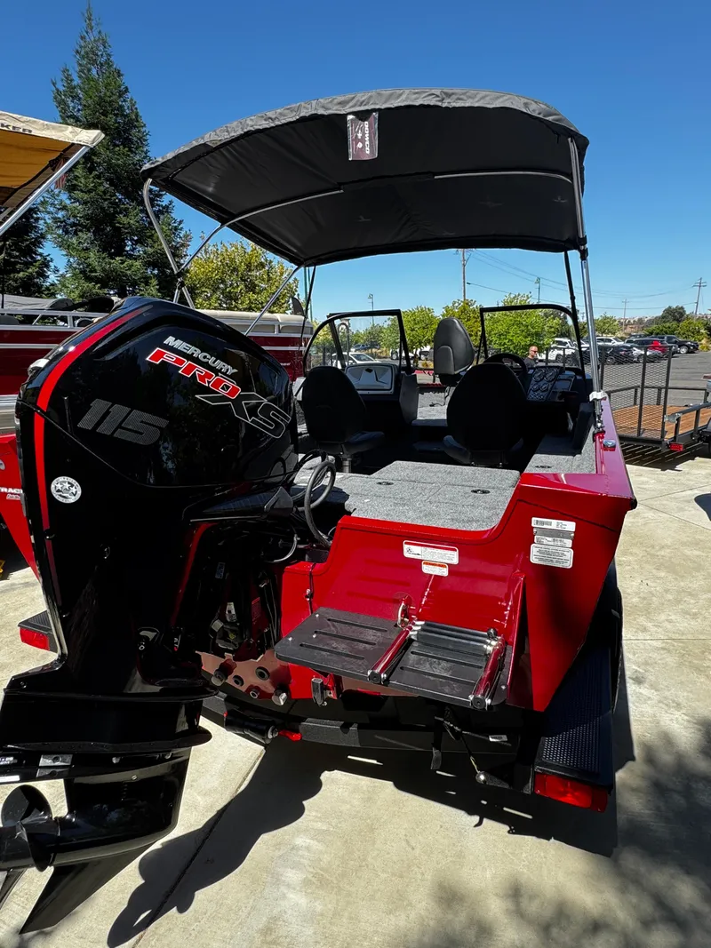 Slide: The Image of 2025 Tracker Pro Guide V-175 Combo boat with Mercury 115 engine, parked outdoors. - 2