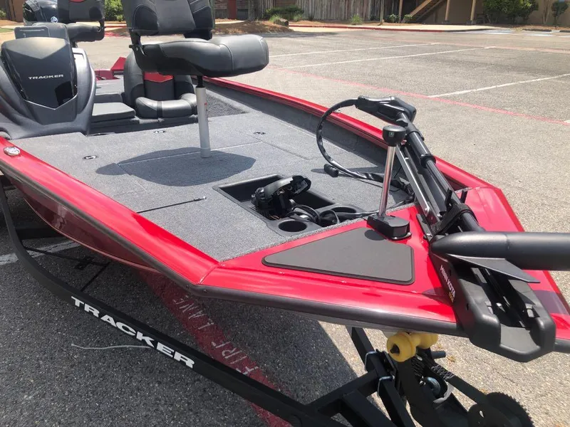 Slide: The Image of 2025 Tracker Pro Team 175 boat with red trim and seating, parked on a trailer. - 7