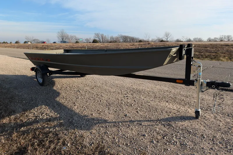 Slide: The Image of 2025 Tracker Grizzly 15 Jon boat on trailer, parked on gravel road. - 26