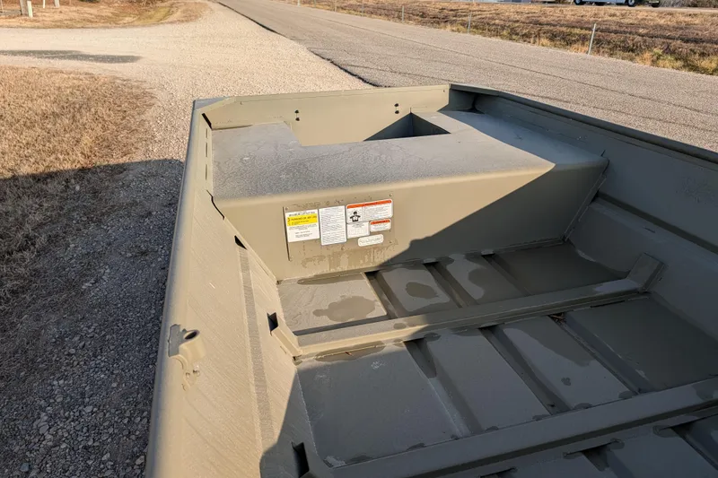 Slide: The Image of 2025 Tracker Grizzly 15 Jon boat interior, showing rugged design on a gravel road. - 29