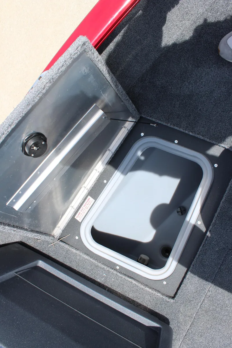 Slide: The Image of 2025 Tracker Pro Guide V-175 Combo boat storage compartment, open lid, carpeted interior. - 20