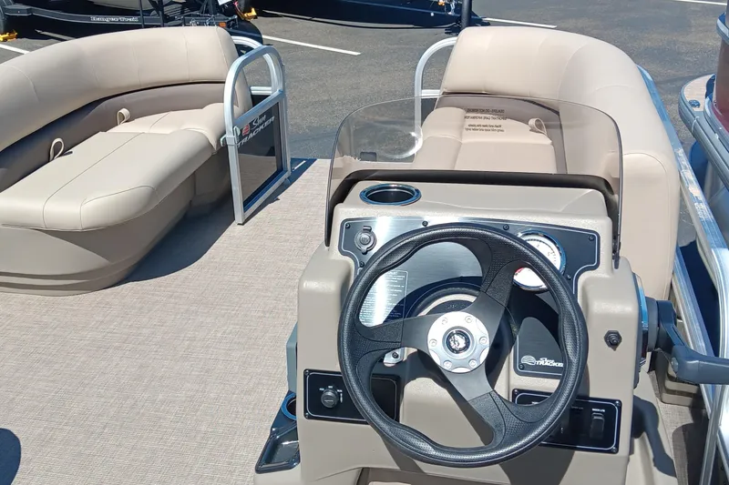Slide: The Image of 2025 Sun Tracker Party Barge 16 DLX interior with steering wheel and seating. - 2