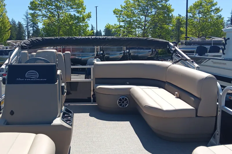 Slide: The Image of 2025 Sun Tracker Party Barge 16 DLX interior with seating and canopy, surrounded by trees. - 3