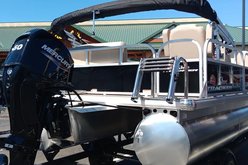 Slide: The Image of 2025 Sun Tracker Party Barge 16 DLX pontoon boat with Mercury engine, docked outdoors. - 4
