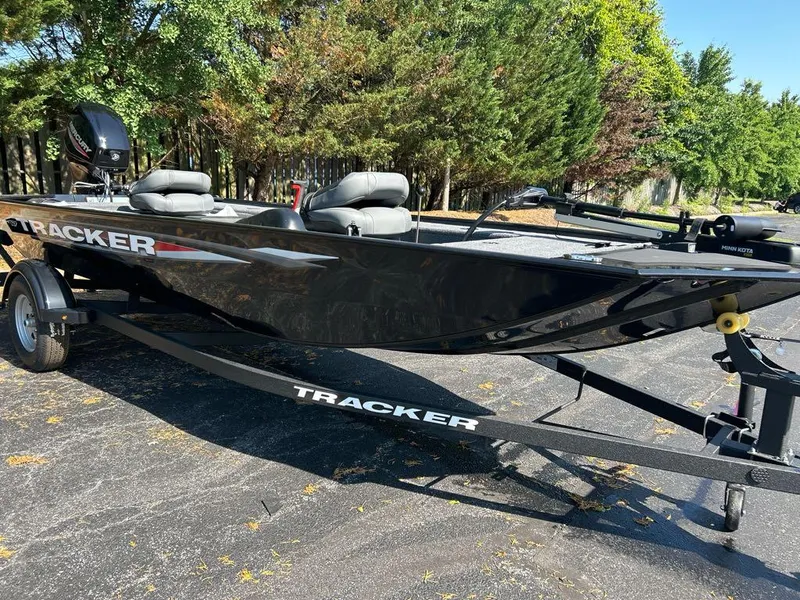 The Image of 2025 Tracker Panfish 17 boat on trailer, parked outdoors, surrounded by trees. - 0