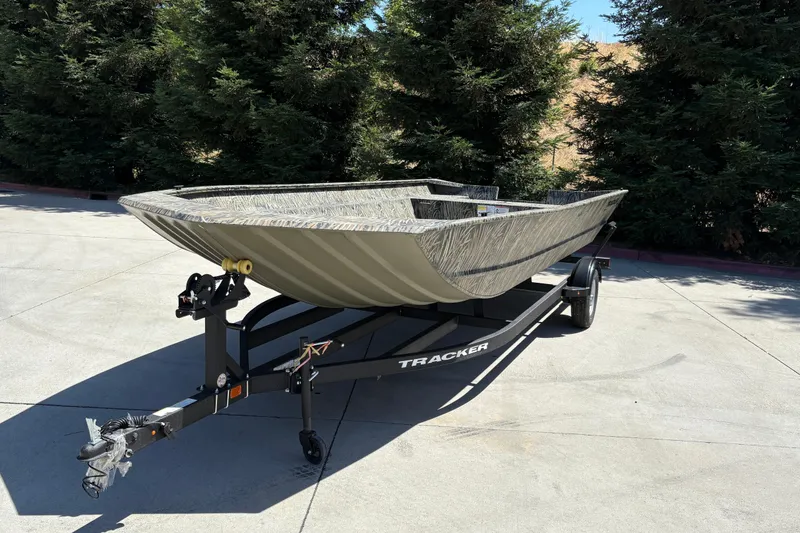 Slide: The Image of 2025 Tracker Grizzly 2072 Utility boat on trailer, parked outdoors near trees. - 13