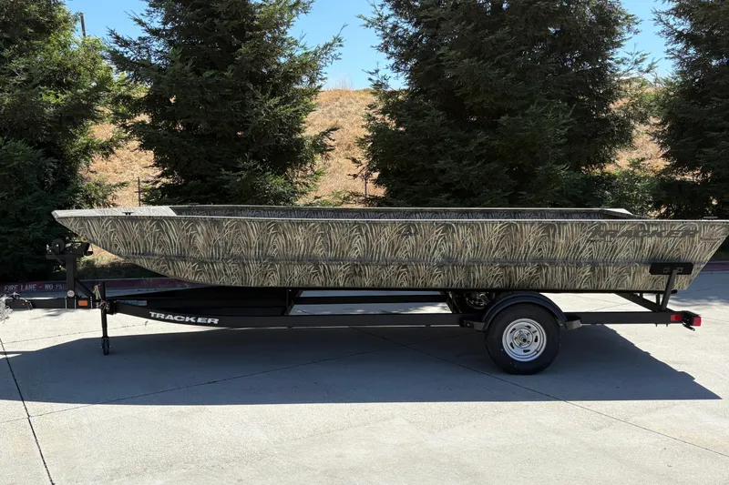 Slide: The Image of 2025 Tracker Grizzly 2072 Utility boat on trailer, camo design, parked outdoors. - 5
