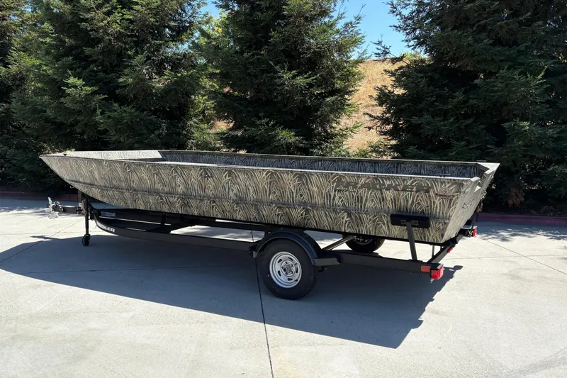 Slide: The Image of 2025 Tracker Grizzly 2072 Utility boat on trailer, camo design, parked outdoors. - 8