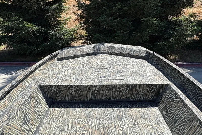 Slide: The Image of 2025 Tracker Grizzly 2072 Utility boat with camouflage pattern, surrounded by trees. - 17