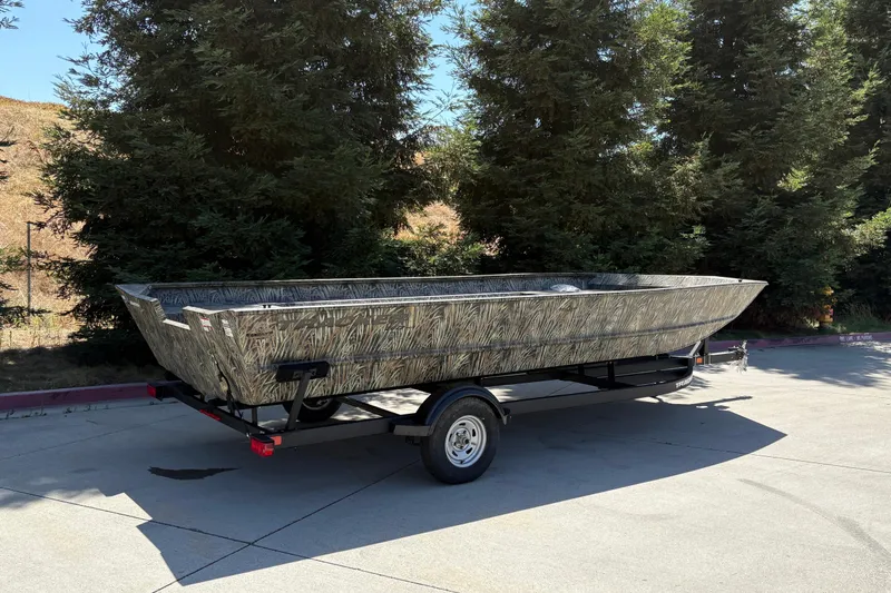 Slide: The Image of 2025 Tracker Grizzly 2072 Utility boat on trailer, camo design, parked outdoors. - 9