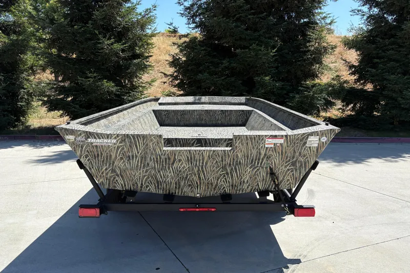 Slide: The Image of 2025 Tracker Grizzly 2072 Utility boat with camo design, parked outdoors. - 12