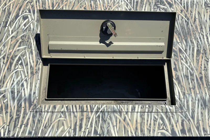 Slide: The Image of Open storage compartment on 2025 Tracker Grizzly 2072 Utility boat with camouflage pattern. - 22