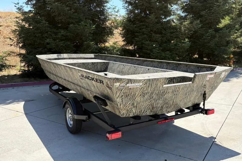 Slide: The Image of 2025 Tracker Grizzly 2072 Utility boat on trailer, camo design, parked outdoors. - 14