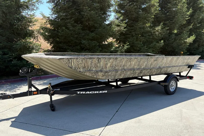 Slide: The Image of 2025 Tracker Grizzly 2072 Utility boat on trailer, camo design, parked outdoors. - 11
