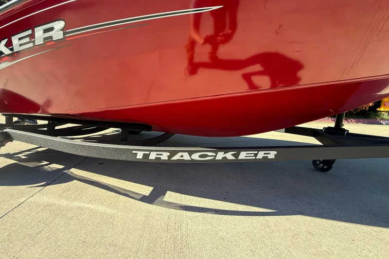 Slide: The Image of 2025 Tracker Super Guide V-16 T boat on trailer, red hull, outdoor setting. - 10