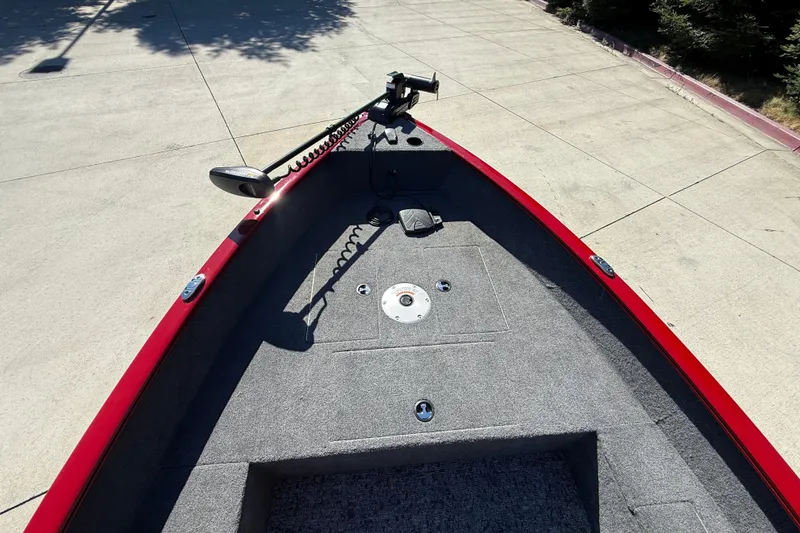 Slide: The Image of 2025 Tracker Super Guide V-16 T boat deck with red trim and trolling motor. - 14