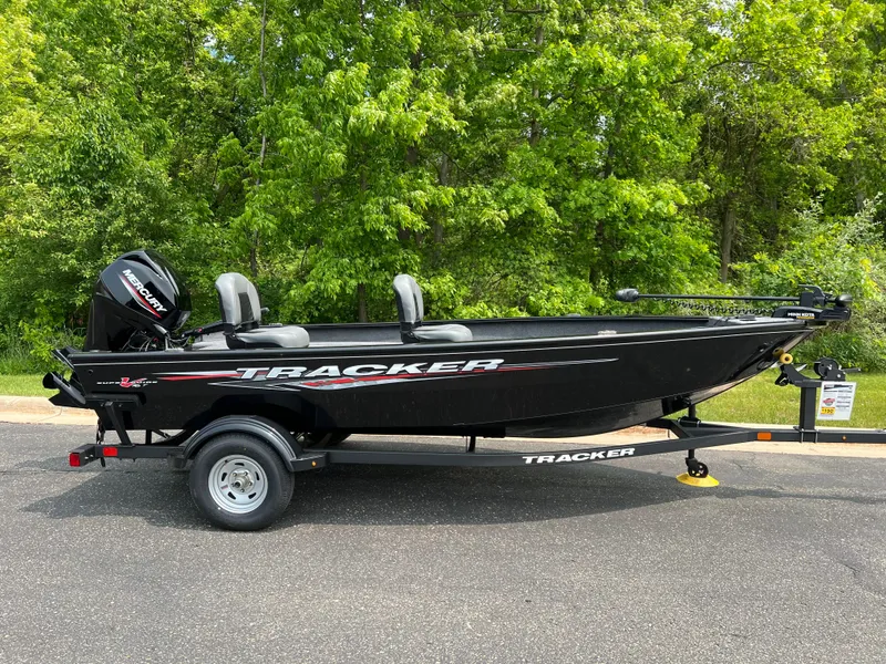 Slide: The Image of 2025 Tracker Super Guide V-16 T boat on trailer, parked outdoors. - 2