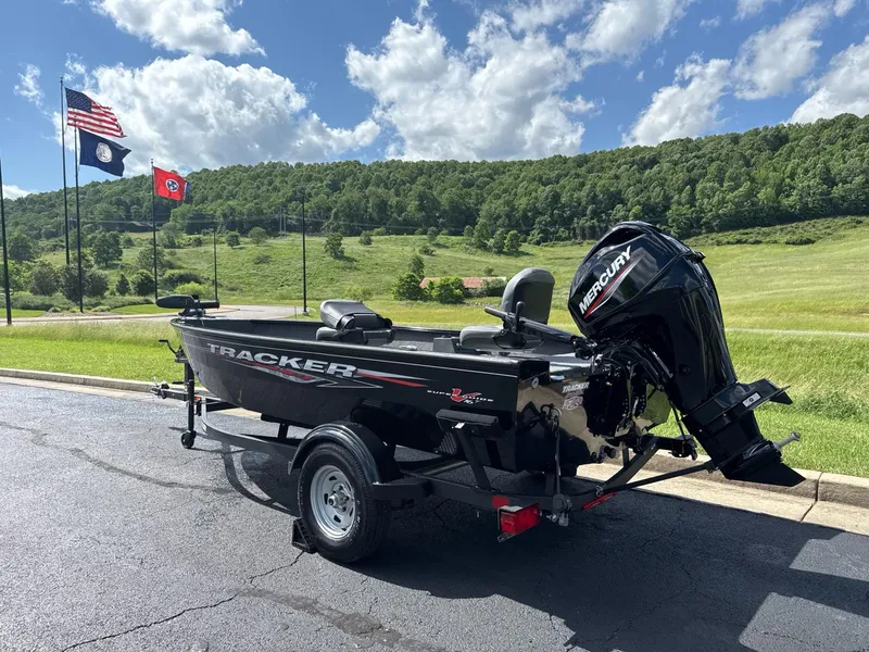 Slide: The Image of 2025 Tracker Super Guide V-16 T boat with Mercury engine, parked outdoors under a clear sky. - 4