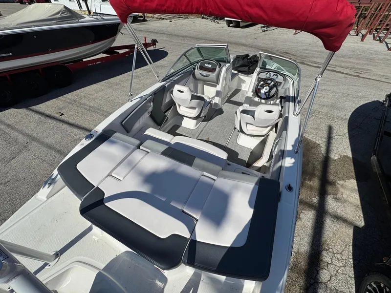 Slide: The Image of 2020 Chaparral 19 SSi OB boat with red canopy, spacious seating, and sleek design. - 9