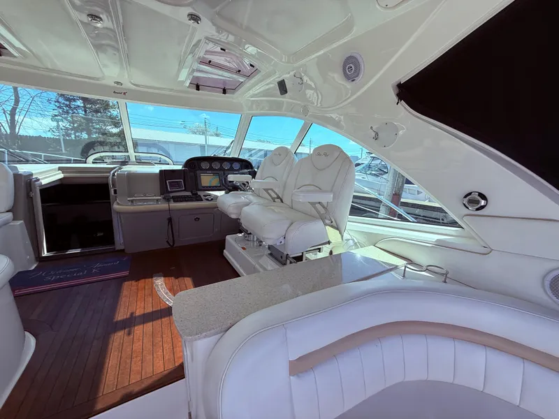 Slide: The Image of 2009 Sea Ray 48 Sundancer interior with luxurious white seating and modern dashboard. - 13