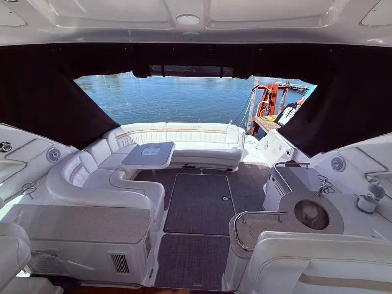 Slide: The Image of 2009 Sea Ray 48 Sundancer yacht interior with seating, table, and water view. - 16